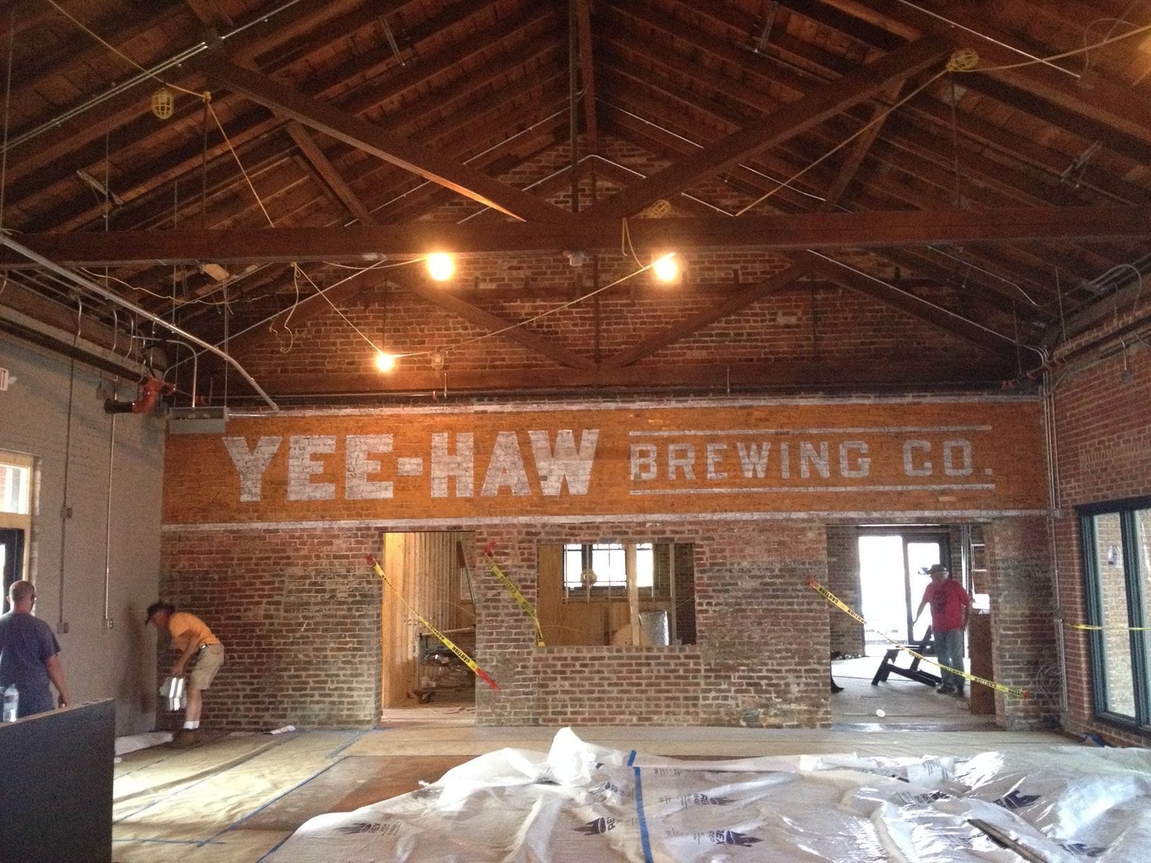 Enterior ghosty mural of the Yee Haw Brewing Co. logo sign painted on the enterior brick of the Yee Haw Brewery located in Johnson City, TN
