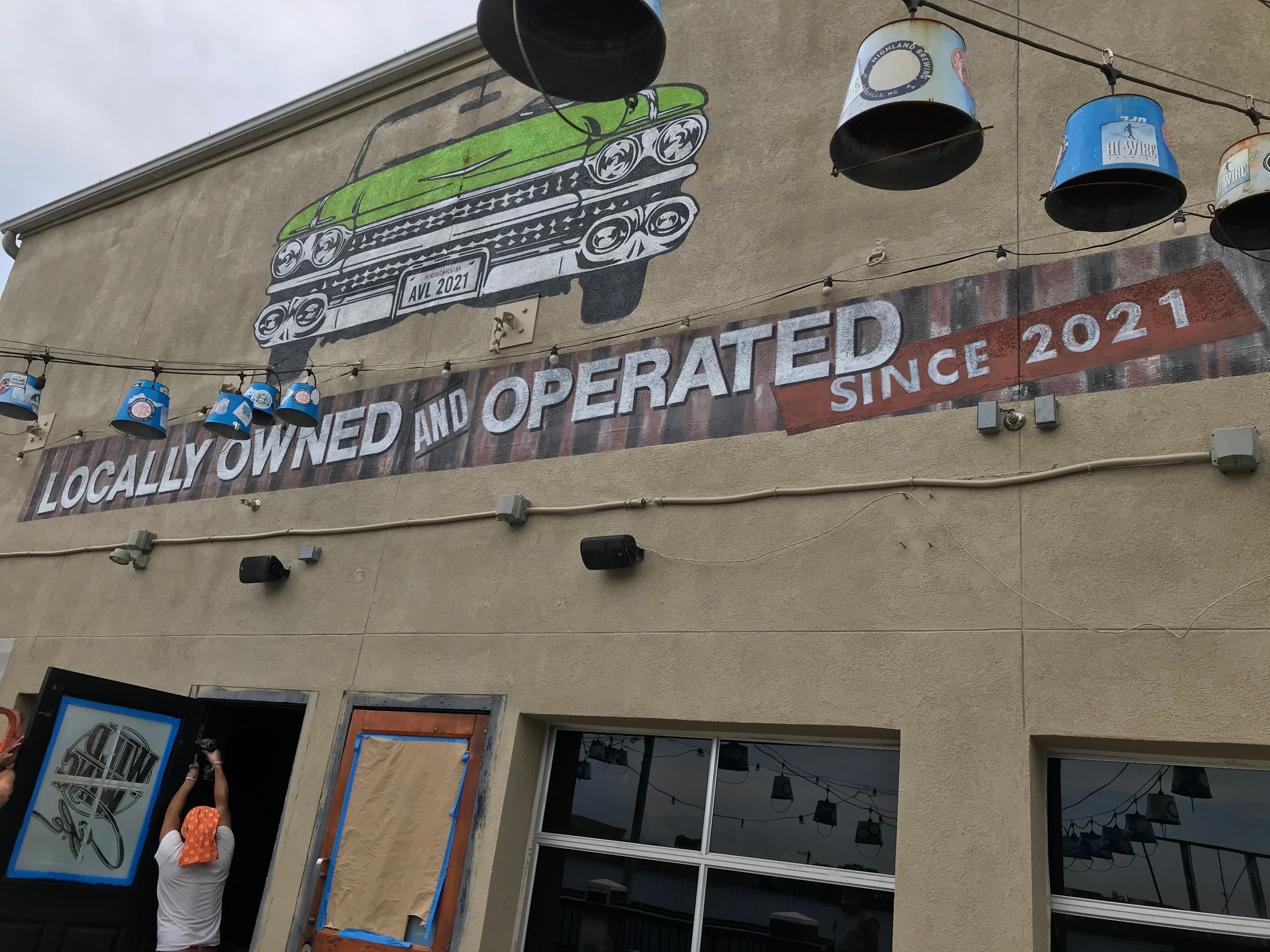 Painted sign, hand lettered and painted Mural on stucco ,on the exterior front of Daddy Mac's Restaurant located in Asheville, NC
