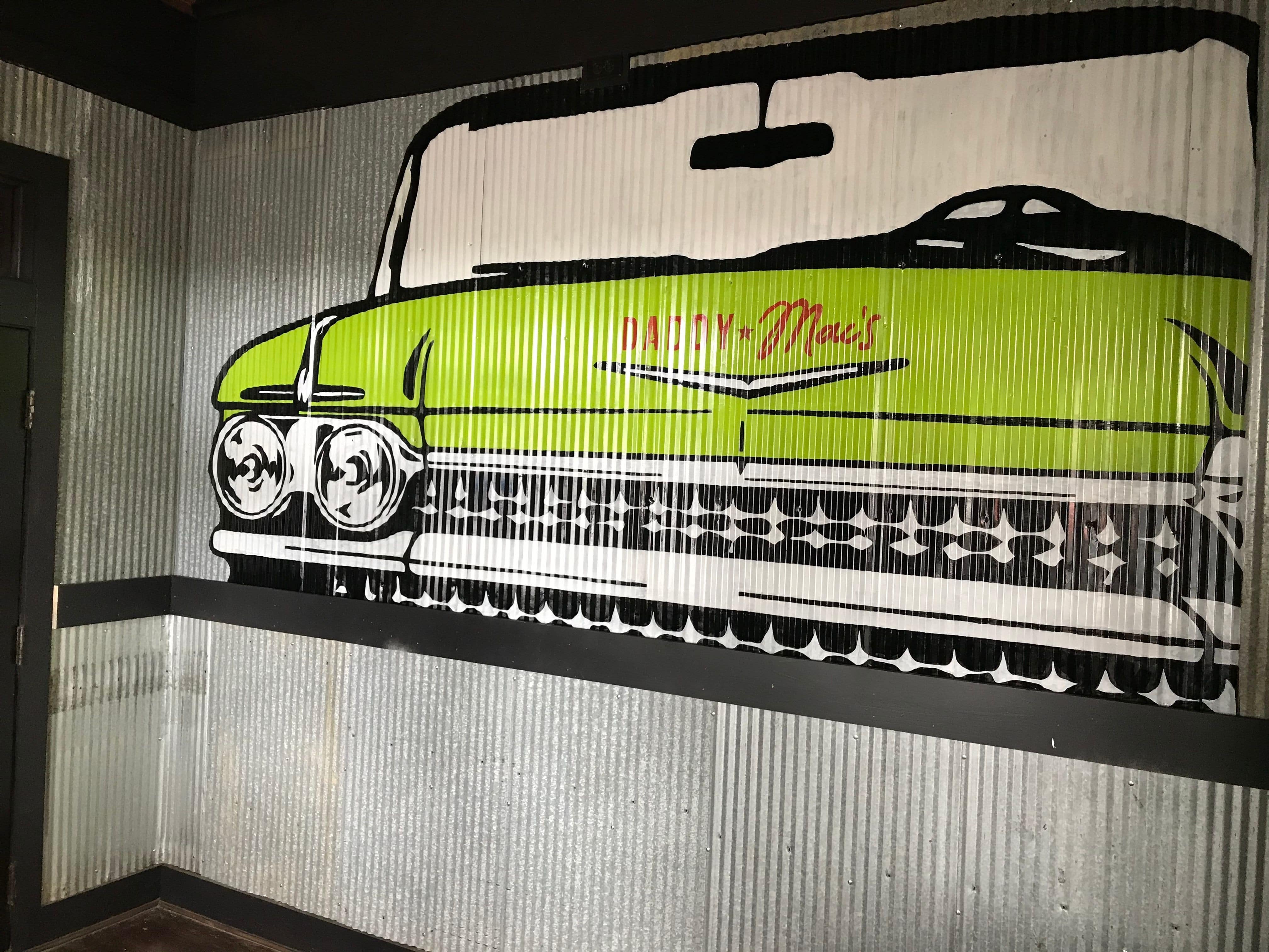 Green Cadillac painted on corrugated metal at the entrance of Daddy Mac's location in Knoxville, TN