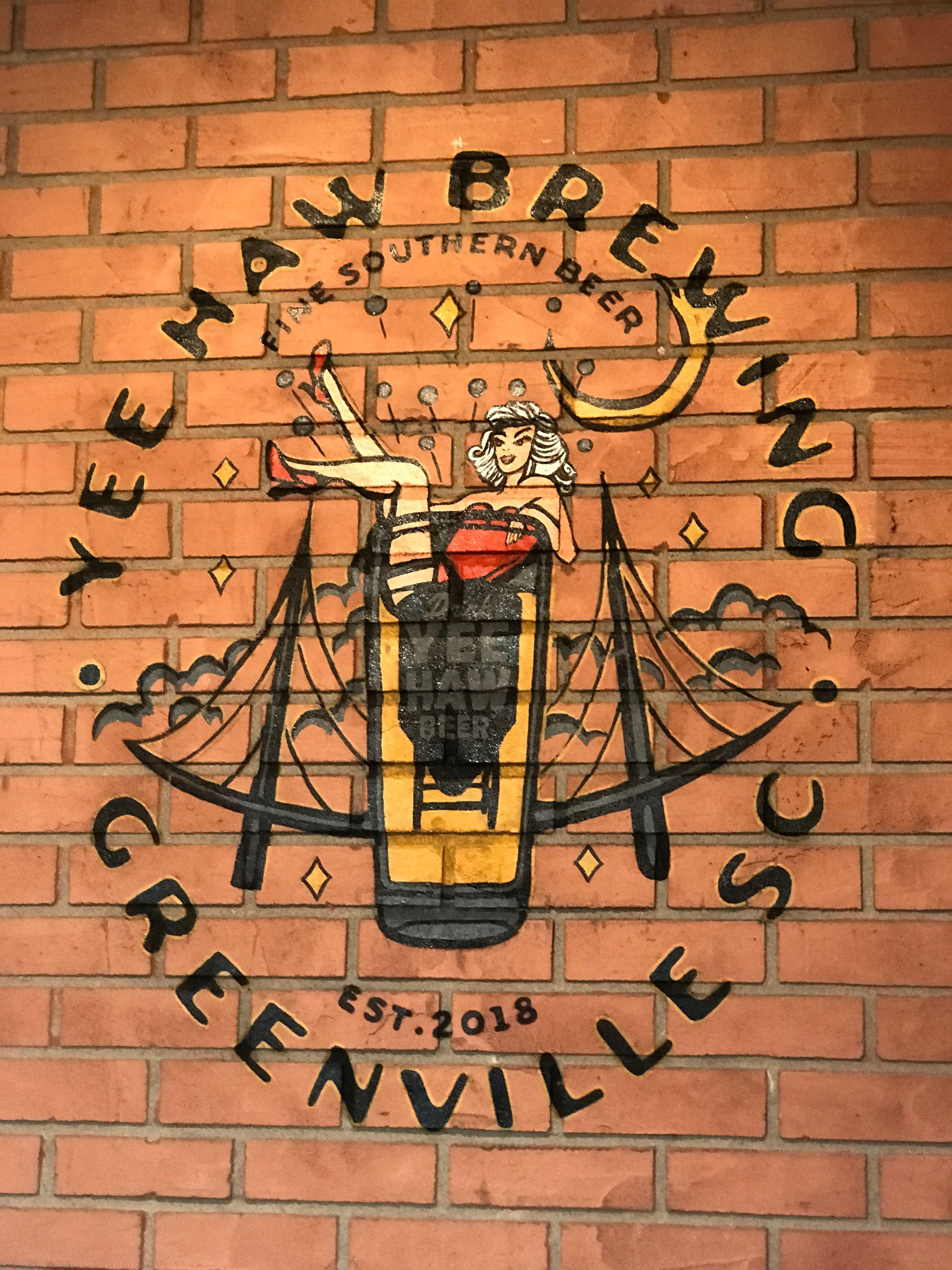 This mural of "the girl in the glass" is a Yee Haw Brewing Co. beer logo painted on interior brick of brewery located in downtown Greenville,SC