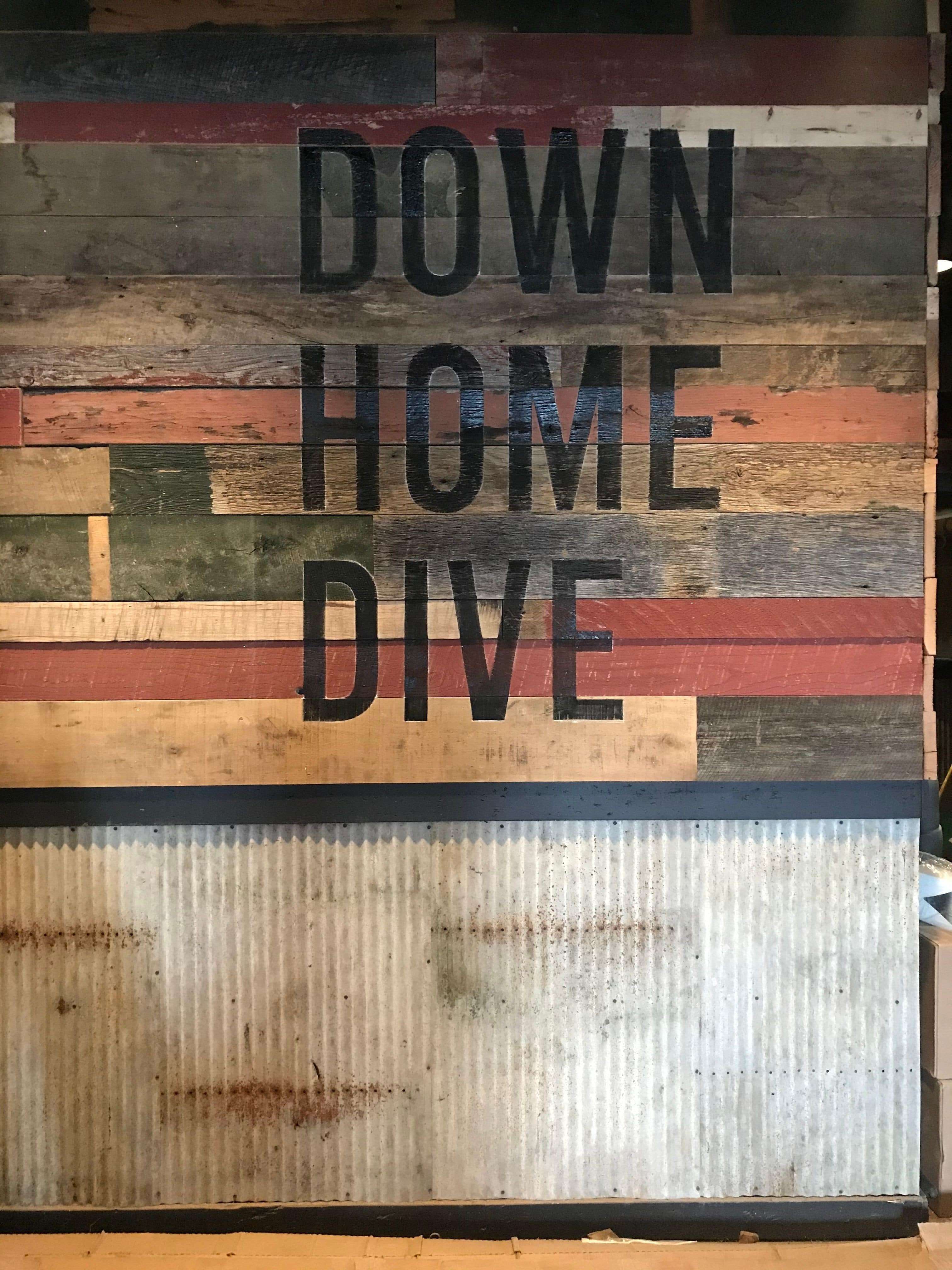 Painted slogan sign on painted barnwood.