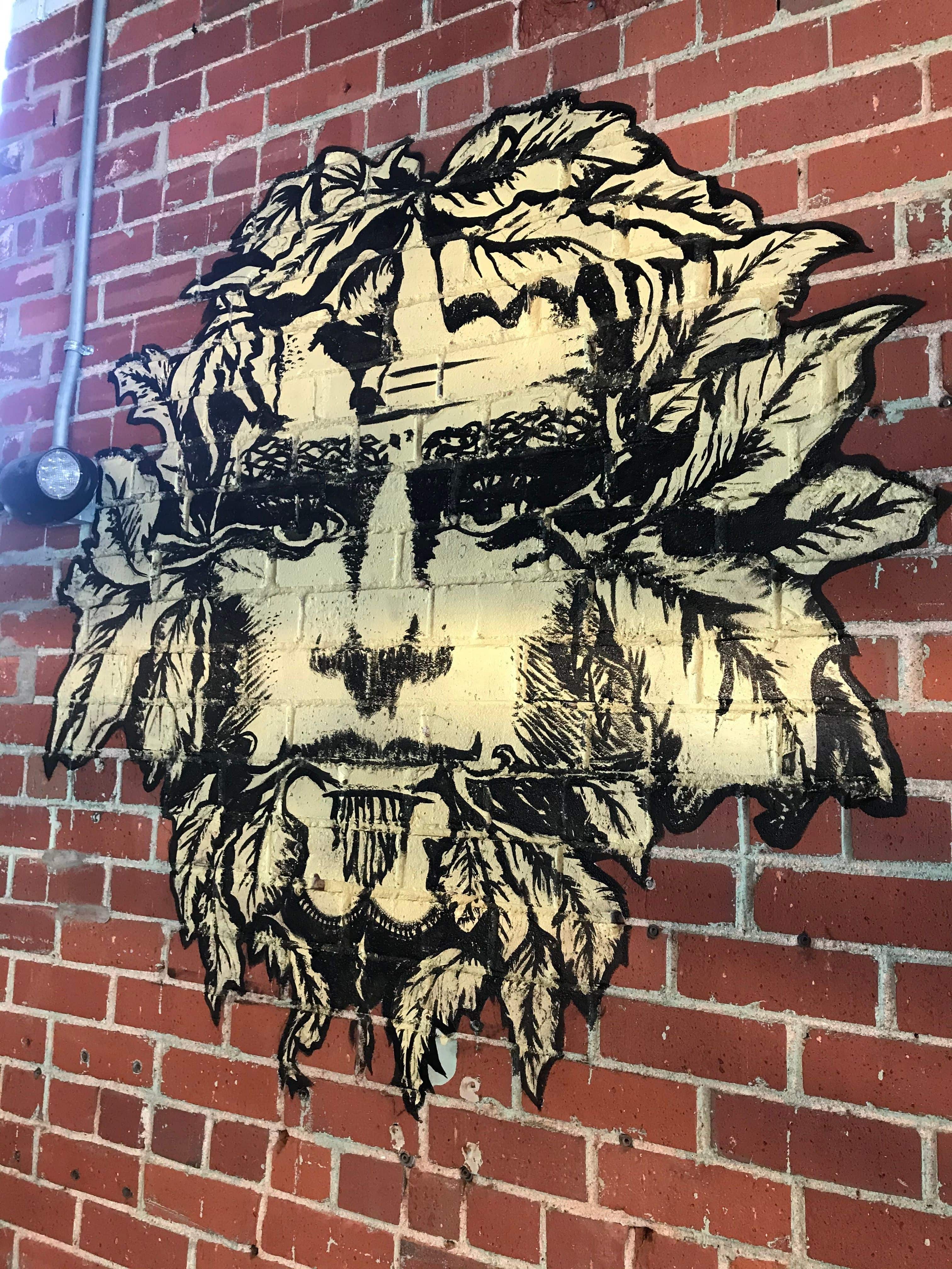 Painted mural on brick of The Green Man Beer Logo
at Yee Haw Brewing Co. in Greenville, SC