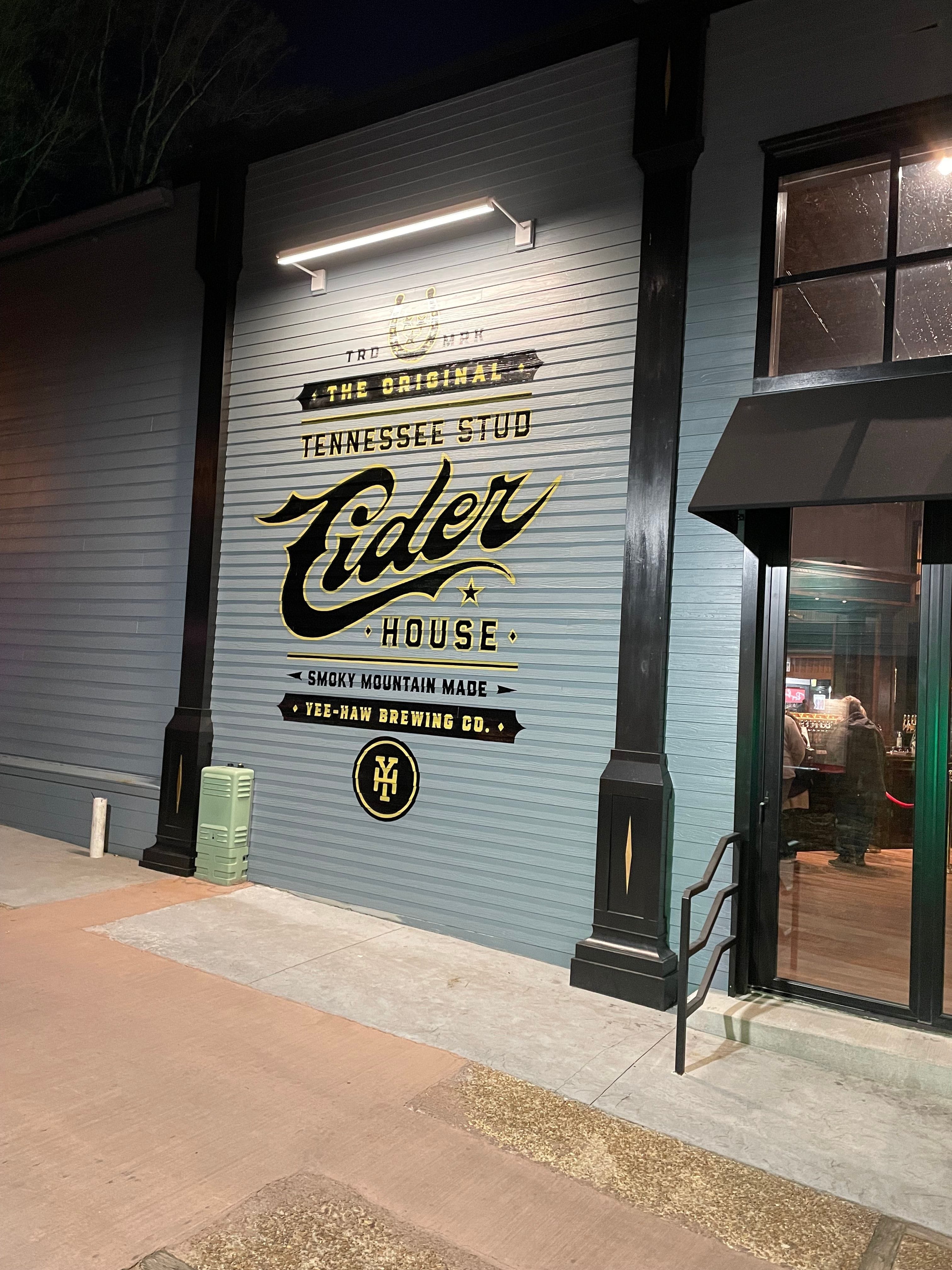 Painted logo of The Tennessee Stud Cider House on the exterior lap siding on the outside of the business located in Gatlinburg,TN